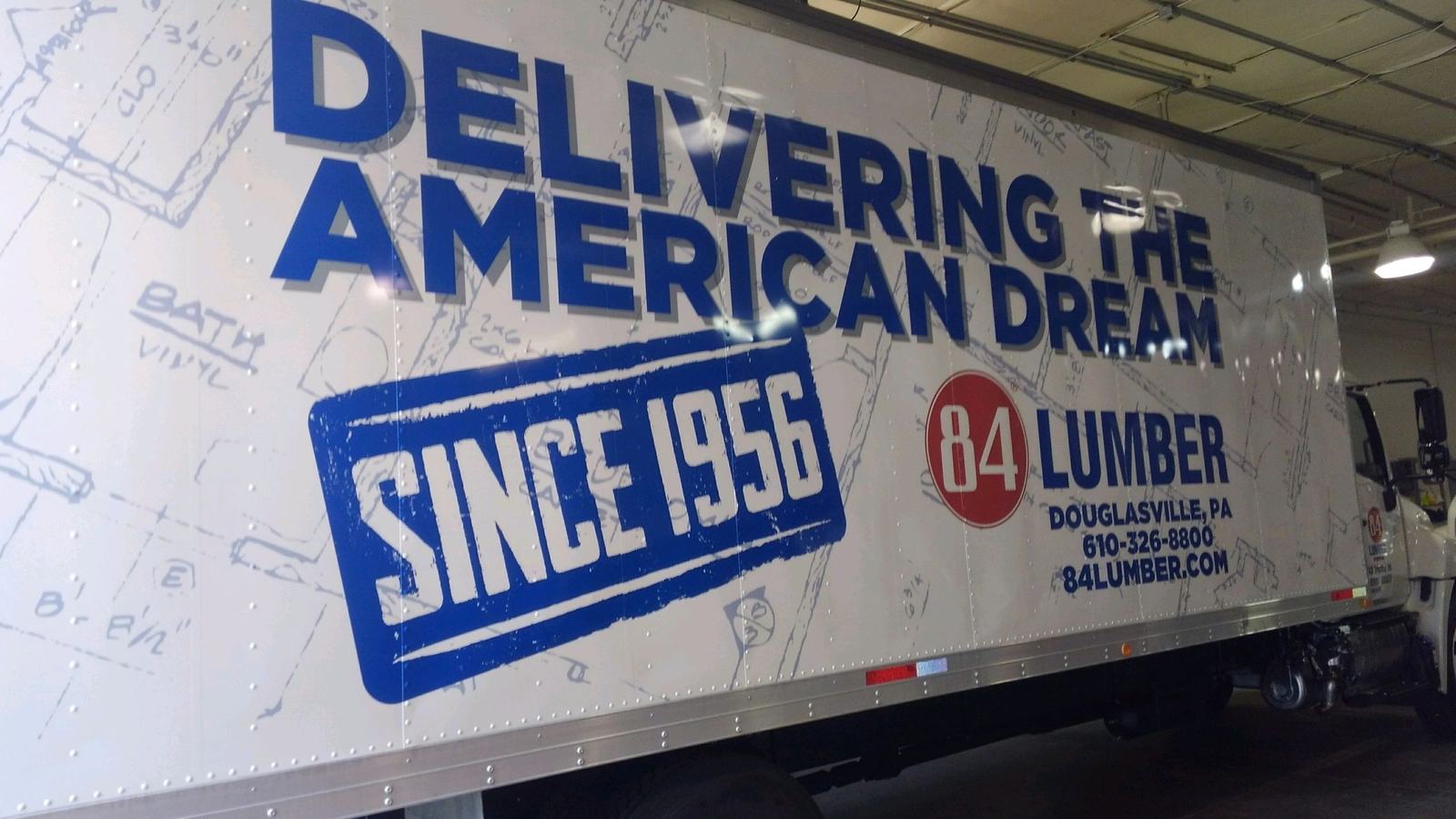 Side of an 84 Lumber box truck reading Delivering the American Dream Since 1956