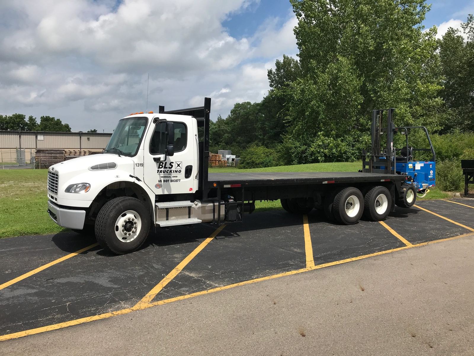 BLS Trucking flatbed truck with a piggyback forklift